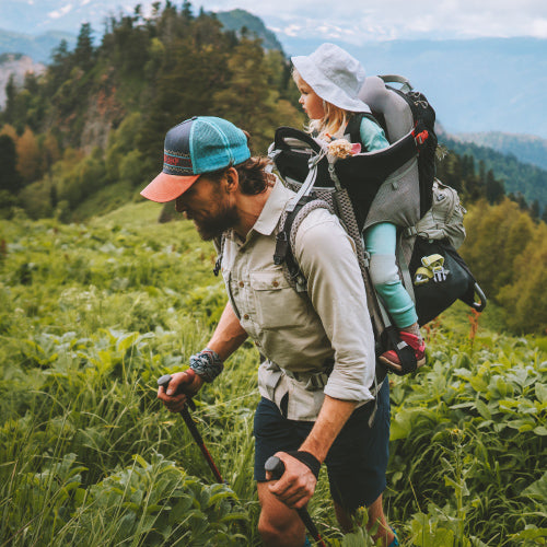 Randonneur portant son enfant dans un sac de randonnée spécial bébé